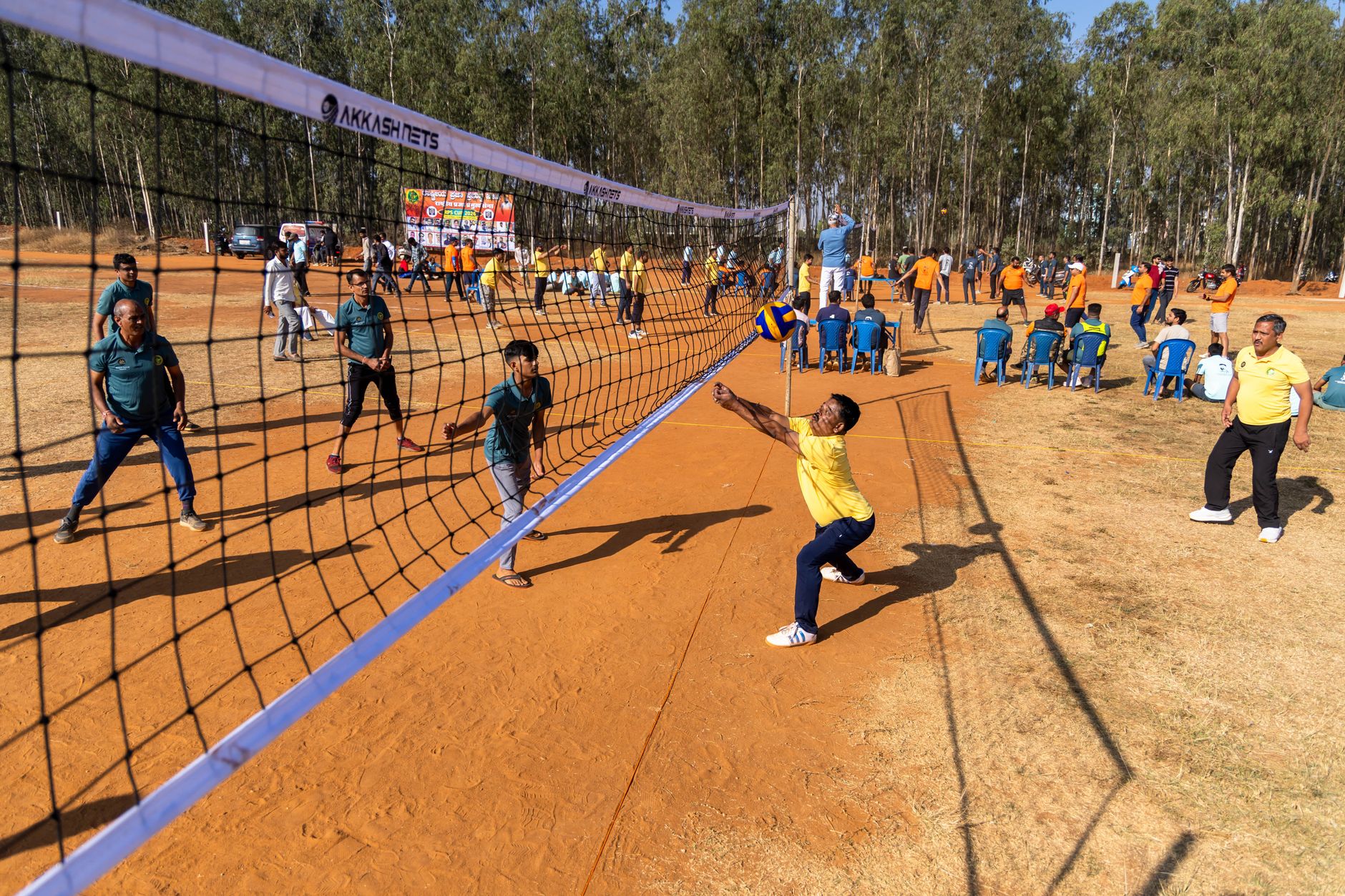 Engaging outdoor volleyball match with active players surrounded by nature.